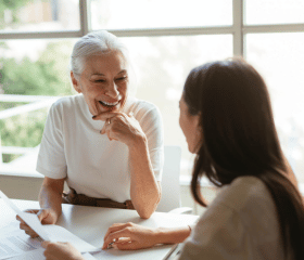 photo d'une dame souriante qui transmet un document